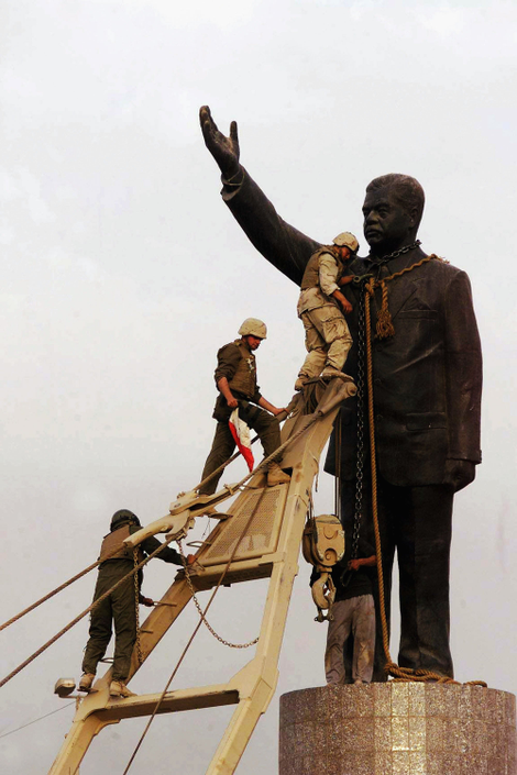 Marines pull down a statue of Saddam Hussein in al-Fardous Square, 2003. Image via Getty.